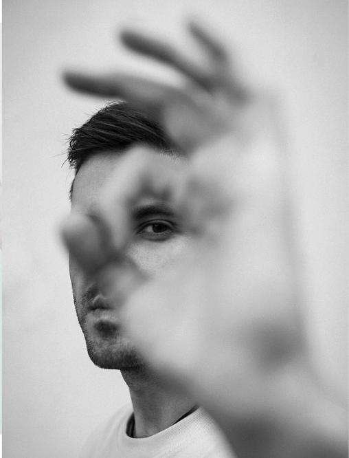 Personne regardant à travers un cercle formé avec ses doigts, symbolisant la recherche de clarté et d’identité personnelle.