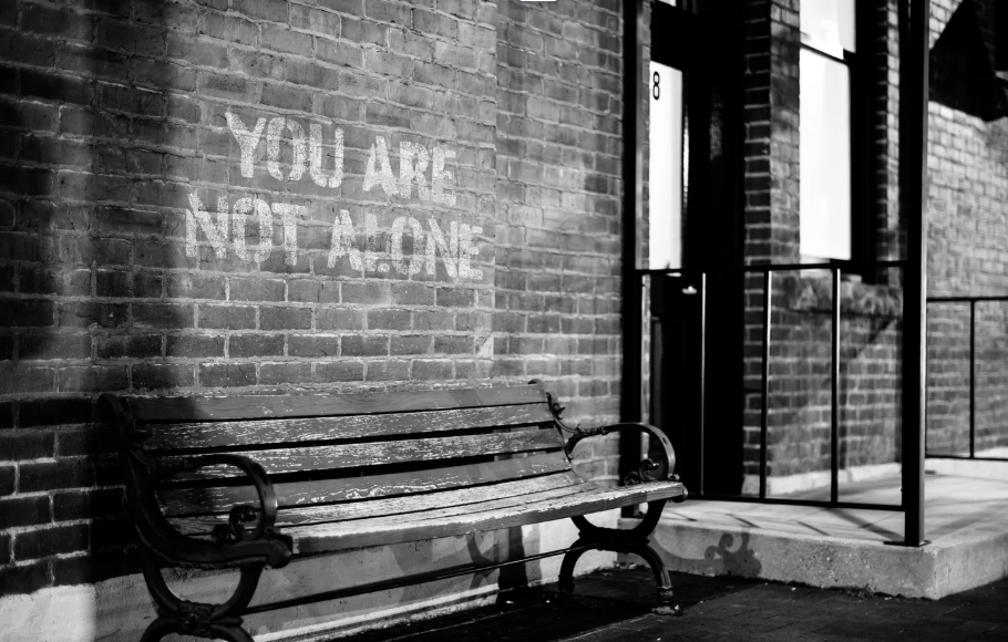 Banc public avec un graffiti indiquant vous n'êtes pas seul.